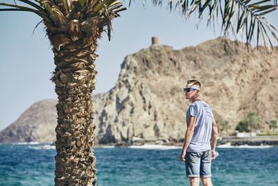 Man wearing sunglasses while standing at beach