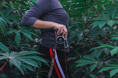 Midsection of man holding plant