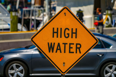 Close-up of yellow sign on road