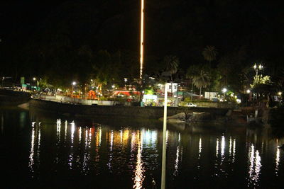 Illuminated buildings by lake at night