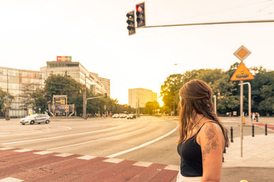 Rear view of woman standing on city street