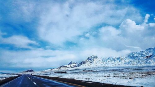 Scenic view of sea and mountains against blue sky