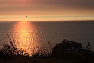 Scenic view of sea against orange sky