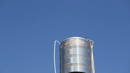 Low angle view of factory against clear blue sky