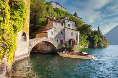 Scenic view of river by buildings against sky