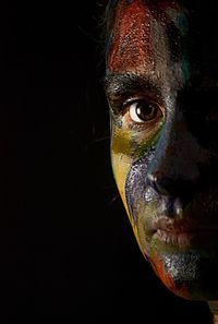 Close-up portrait of young man against black background