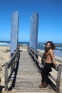 Full length of woman standing on pier at sea 