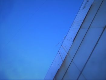 Low angle view of sailboat against clear blue sky