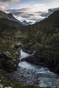 River flowing amidst mountains against sky