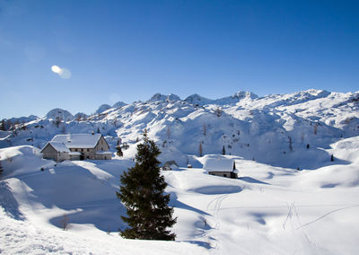 Scenic view of snowcapped mountains against clear blue sky