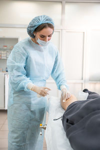 Low angle view of female dentist examining patient in laboratory