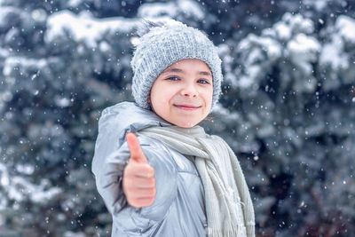 Portrait of smiling young woman standing in snow