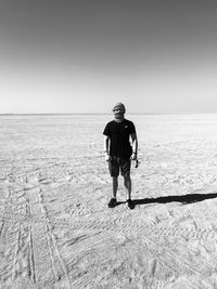 Portrait of man standing on desert against clear sky