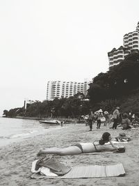 People at beach against clear sky