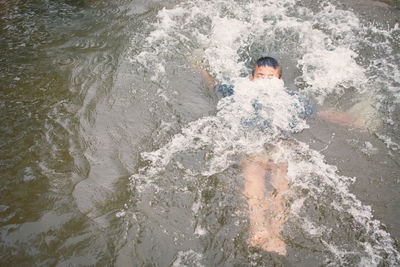 Boy swimming in lake