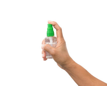 Close-up of hand holding cigarette over white background