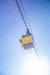 Low angle view of overhead cable cars against clear sky