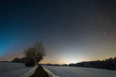 Scenic view of snow covered landscape against sky at night