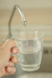 Cropped image of hand pouring water in glass