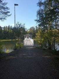 Footpath amidst trees against sky