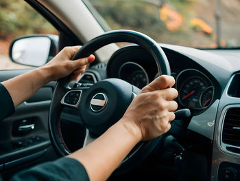 Cropped hand of man driving car