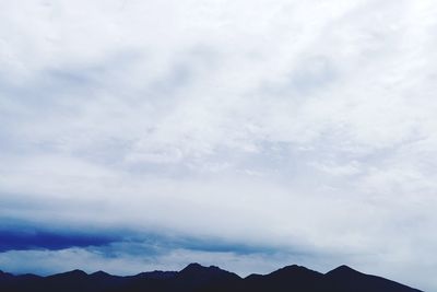 Scenic view of mountains against cloudy sky