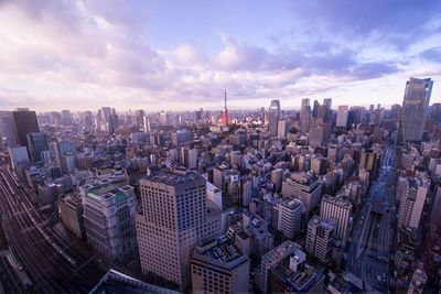 Tokyo tower amidst cityscape against sky