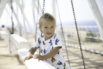 Portrait of boy sitting on swing