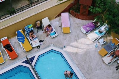 High angle view of woman sitting by swimming pool