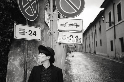 Low angle view of man standing against graffiti wall