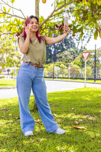 Portrait of smiling young woman standing on field