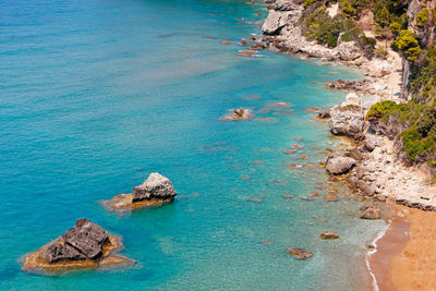 High angle view of rocks on sea shore