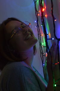 Portrait of young woman with illuminated lighting equipment at night