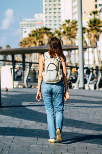 Full length rear view of woman walking in city