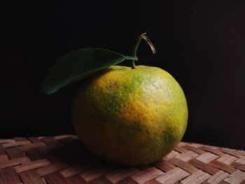 Close-up of apple on table against black background