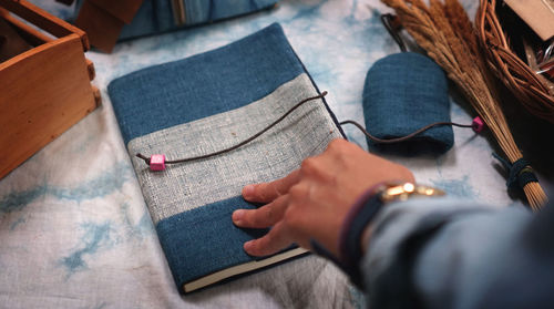 Cropped hand holding book on table