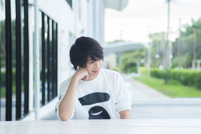 Portrait of young woman sitting outdoors