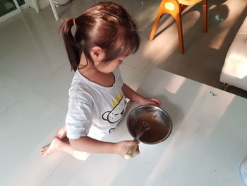 High angle view of cute girl sitting on floor