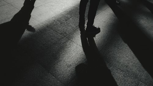 Low section of silhouette man standing on floor
