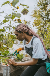 Young female environmentalist planting vegetables in organic farm