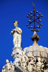 Statues and carvings on saint mark basilica against clear blue sky