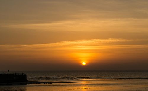 Scenic view of sea against orange sky