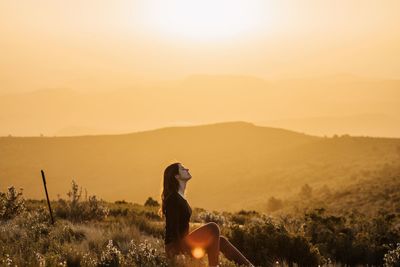 Man standing on mountain against sky during sunset