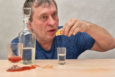 Portrait of man drinking glasses on table