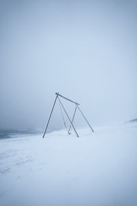 Windmill on snow covered field against sky