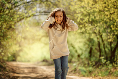 Little pretty girl on walk in sunny spring park. fairy forest. child with long hair listens to music