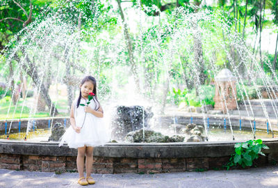 Full length of girl splashing water