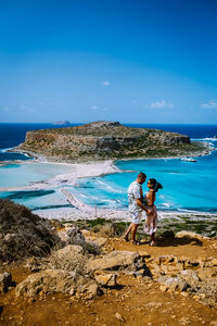 People standing on beach against blue sky