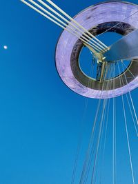 Low angle view of ferris wheel against blue sky