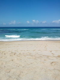 Scenic view of beach against blue sky